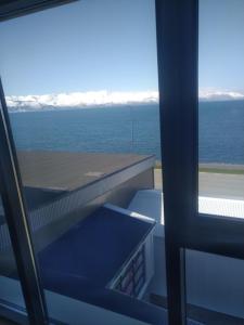 uma vista para o oceano a partir de um quarto com uma janela em Guesthouse Maddy em Húsavík