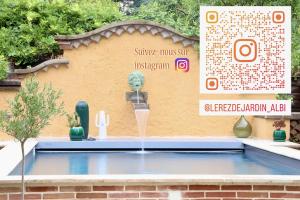 a water fountain in front of a building with a sign at Le Rez de Jardin Albi in Albi