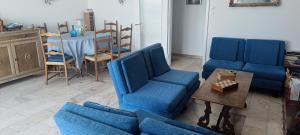 a living room with blue chairs and a table at Locazione Turistica Sul Mare Strada Costiera 244, Trieste in Santa Croce Mare