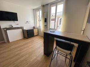 a living room with a desk and a chair at Brown Cosy in Louviers