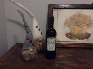 a bottle of wine next to a stuffed animal and a picture at lo Tsanty in Aosta