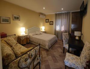 a bedroom with a bed and a desk and chairs at Tenuta Aranuova in Vercelli