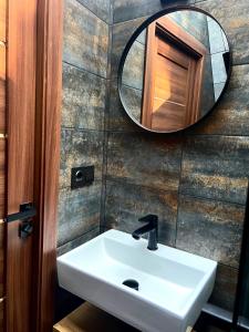 a bathroom with a sink and a mirror at CallTipi glass house in Kalgriaužiai