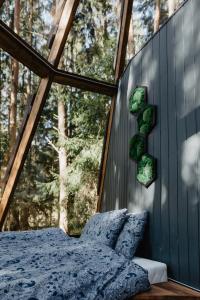a bedroom with a bed and a large window at CallTipi glass house in Kalgriaužiai