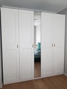 a bedroom with white cabinets and a bed at Apartament Wyłom 8 in Poznań