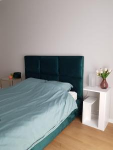 a bedroom with a blue bed and a white nightstand at Apartament Wyłom 8 in Poznań