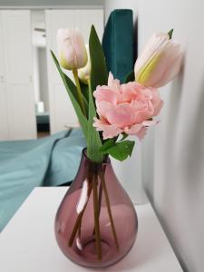 a pink vase filled with pink and white flowers at Apartament Wyłom 8 in Poznań