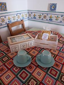 uma mesa com dois conjuntos de chá em cima de um tapete em casale nonna Elisa relax tra ulivi em San Vito Chietino