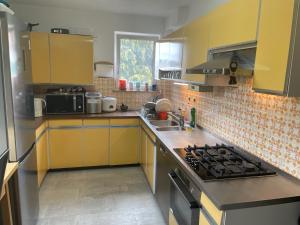 格爾林根的住宿－Sehr schöne Wohnung in 70839 Gerlingen in Deutschland，厨房配有黄色橱柜和炉灶烤箱
