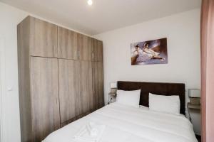 a bedroom with a bed and a wooden cabinet at KNL luxury apartment by homebrain in Alexandroupoli