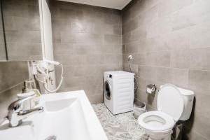 a bathroom with a toilet and a washing machine at KNL luxury apartment by homebrain in Alexandroupoli