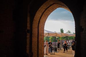 um arco em um edifício com um grupo de pessoas em Rocca di Arignano em Arignano