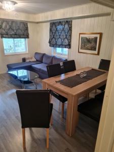 uma sala de estar com uma mesa e um sofá azul em Fjærland Våteviksvegen 17 em Bøyum