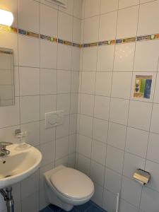 a white bathroom with a toilet and a sink at Appartamento 464 nel CUORE di Locarno con piscina in Locarno