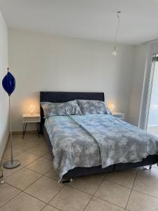 a bedroom with a bed with a blue comforter at Appartamento 464 nel CUORE di Locarno con piscina in Locarno