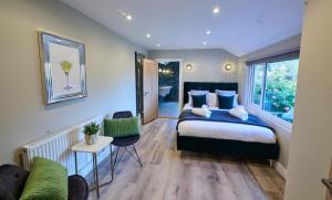 - une chambre avec un lit et un canapé dans l'établissement Luxurious 5-Bed House with Pool, Hot Tub & Parking, à Eastry
