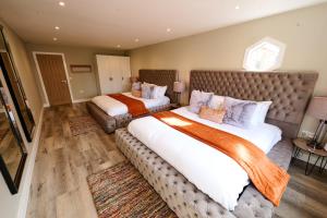 - une grande chambre avec 2 lits et un canapé dans l'établissement Luxurious 5-Bed House with Pool, Hot Tub & Parking, à Eastry