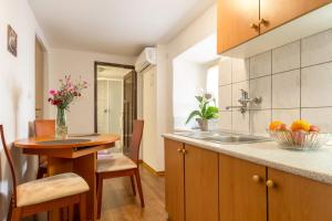 a kitchen with a sink and a table with a bowl of fruit at Bernard Old Town Apartment in Split