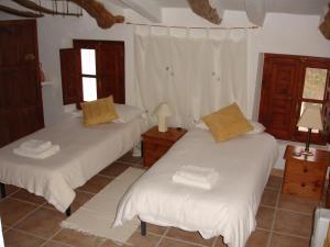 1 dormitorio con 2 camas y 2 ventanas en Almond Reef Casa Rural en Los Alias