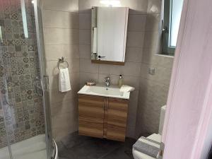La salle de bains est pourvue d'un lavabo et d'une douche. dans l'établissement Viva s apartment, à Metaxáta