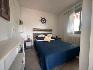 1 dormitorio con 1 cama con manta azul en Appartement La Petite Maison, en Le Grau-du-Roi