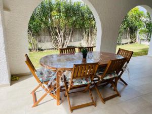 a dining room table with four chairs around it at Villino Oleandro a pochi passi dalla spiaggia di Simius in Simius