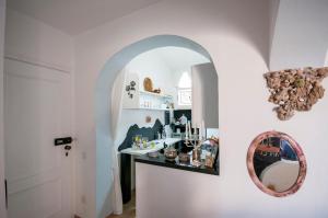 pasillo con espejo y lavabo en la habitación en Myrtus Apartment fronte mare, en Castelsardo