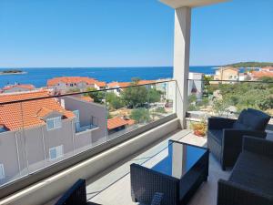 a balcony with chairs and a view of the ocean at Penthouse Dream Look in Rogoznica