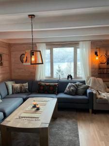 uma sala de estar com um sofá azul e uma mesa em Secluded Holiday Home, With private beach em Ålesund