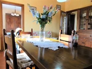 una mesa de comedor con un jarrón de flores. en La Cheta, en Monsagrati