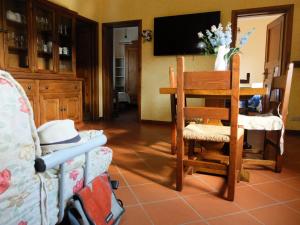sala de estar con mesa, silla y TV en La Cheta, en Monsagrati