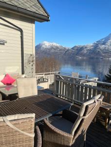 una terraza con sillas y una mesa con vistas al lago en Secluded Holiday Home, With private beach en Ålesund