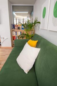 a green couch with two yellow pillows on it at Urban Downtown Suite Xanthi - MenoHomes 4 in Xanthi