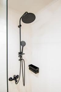a shower with a shower head in a bathroom at Urban Downtown Suite Xanthi - MenoHomes 4 in Xanthi