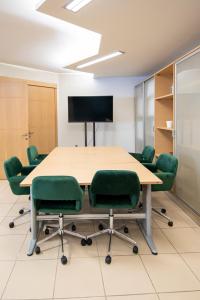 a conference room with a table and green chairs at Urban Downtown Suite Xanthi - MenoHomes 4 in Xanthi