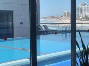vista para uma piscina a partir de um quarto de hotel em דירות נופש מרינה הרצליה em Herzliyya B