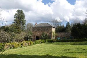 an old brick building in a field with a yard at a quirky garden building in an orchard in Ryton