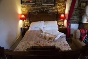 a bedroom with a bed with two lamps on two tables at a quirky garden building in an orchard in Ryton