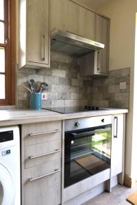 a kitchen with a stove and an oven in it at Cosy secret cottage in a beautiful walled garden in Ryton