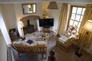 an overhead view of a living room with couches and a television at Cosy secret cottage in a beautiful walled garden in Ryton