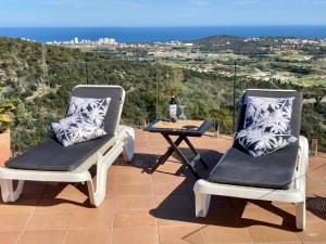 2 sillas y una mesa en un patio con vistas en Villa Gardenia mit Pool und traumhaftem Meerblick, en Santa Cristina d'Aro