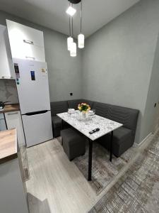 een keuken met een tafel en stoelen en een koelkast bij Comfortable 3-roomed apartment Ozod Apartments in Samarkand