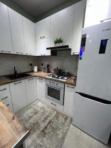 een keuken met witte kasten en een witte koelkast bij Comfortable 3-roomed apartment Ozod Apartments in Samarkand