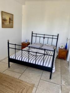 a bedroom with a black bed with striped pillows at Auberge de la Croix du Pape in Éze