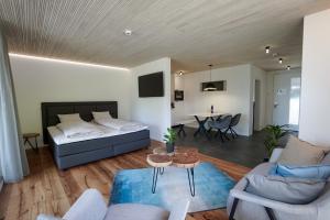 a living room with a bed and a dining room at Seehotel Baumgarten in Kehrsiten