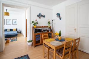 a living room with a dining room table and a kitchen at Diófa Vendégház, Zebegény in Zebegény