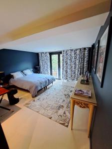 een slaapkamer met een bed en een tafel. bij Havre de paix in Ville-dʼAvray