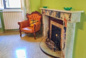 a living room with a chair and a fireplace at Nonna Domenica - Casa Vacanze @Gagliano Aterno in Gagliano Aterno