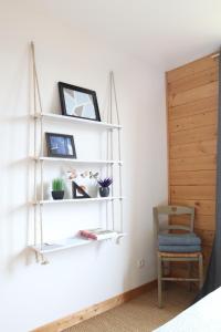 een kamer met witte planken en een blauwe stoel bij Maison ecologique en paille in La Chapelle-Enchérie