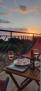 a table with two glasses and a bottle of wine at Cap en Corse in Farinole +4 photos